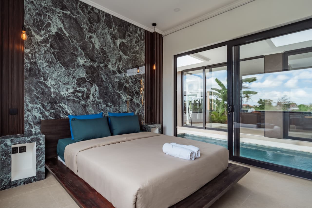 A green marble suite opening to the pool at Villa Ikigai